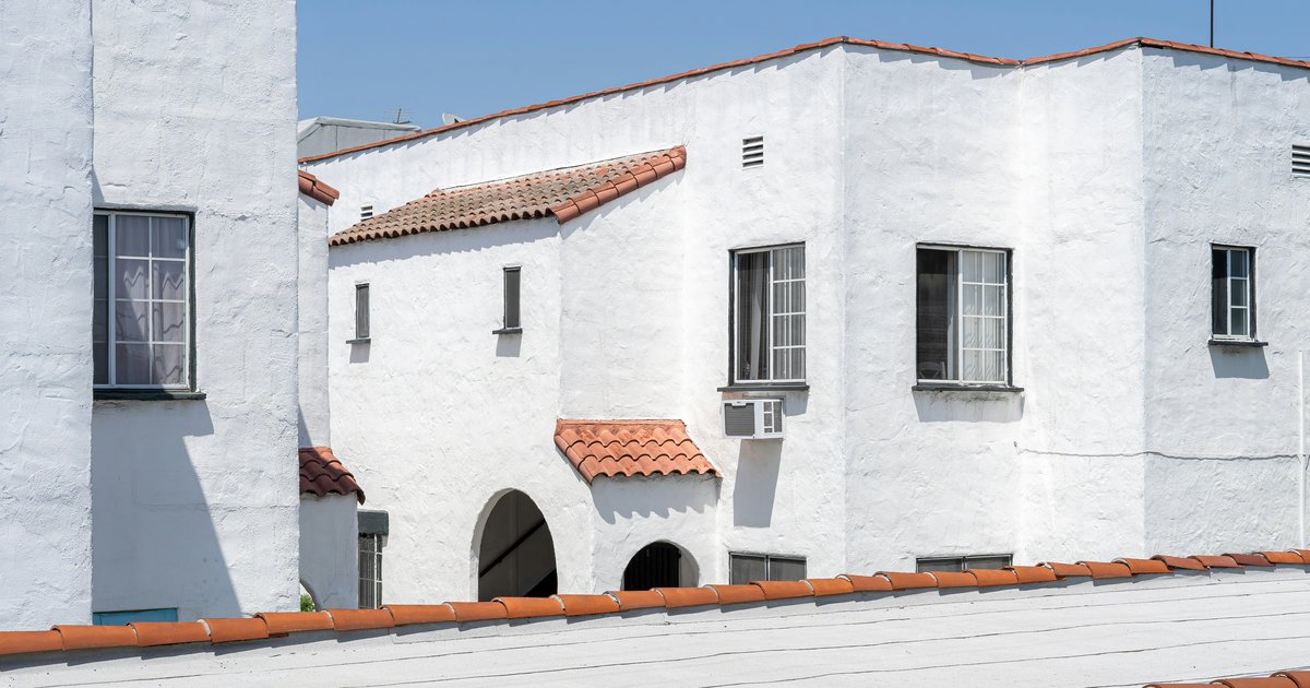 A white Spanish Revival style house with a red clay tile roof