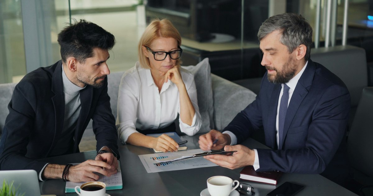A couple reviewing mortgage documents with a loan officer, discussing co-borrower options for their Texas home purchase