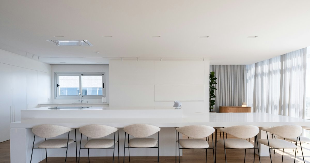 A bright open kitchen with a long white island and counter seating, the kind of layout buyers compare in new builds