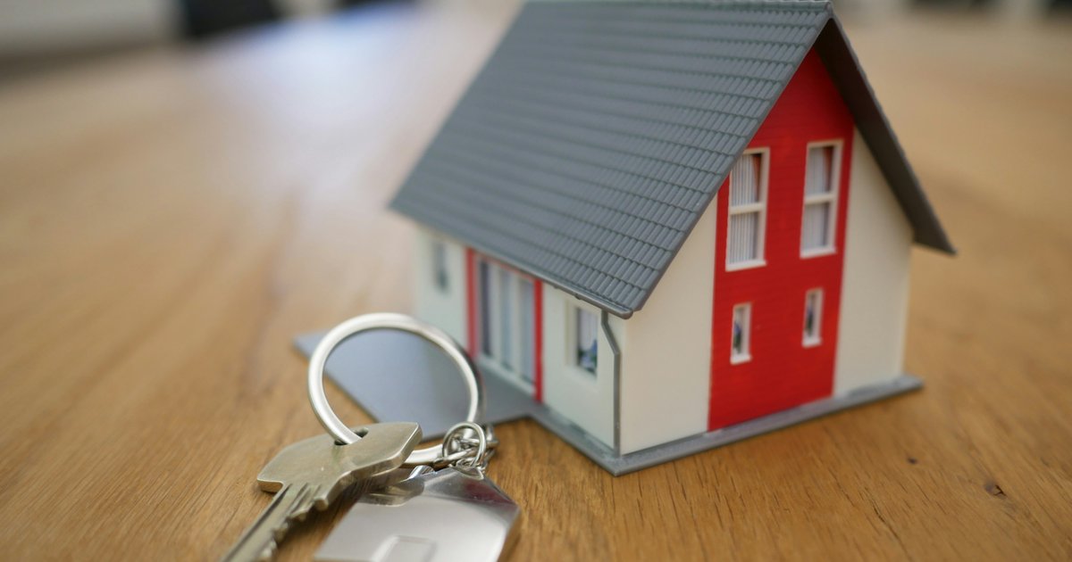 A real estate agent reviews offer documents with a buyer couple at a table