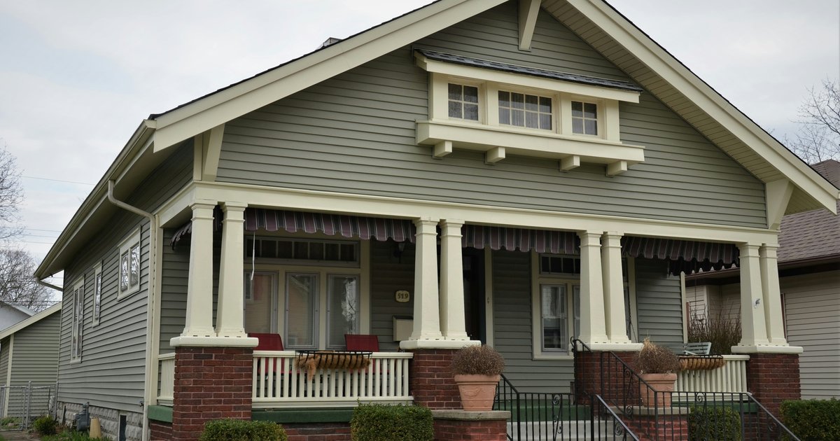 Two-story historic home with a full-width covered front porch and mature landscaping, typical of the pre-war construction in Old East Dallas
