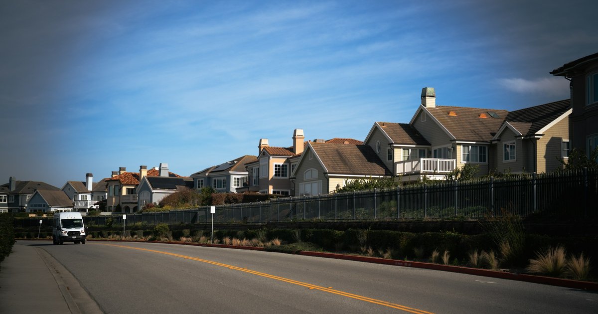 Two-story homes along a quiet street in a Frisco master-planned community, with a minivan parked in a driveway