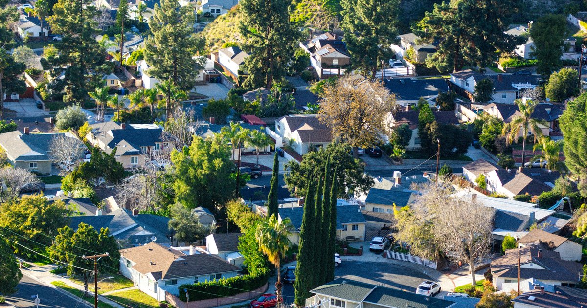 A residential cul-de-sac in the Los Angeles area, showing mature evergreens and a mix of single-story and two-story homes on modest lots