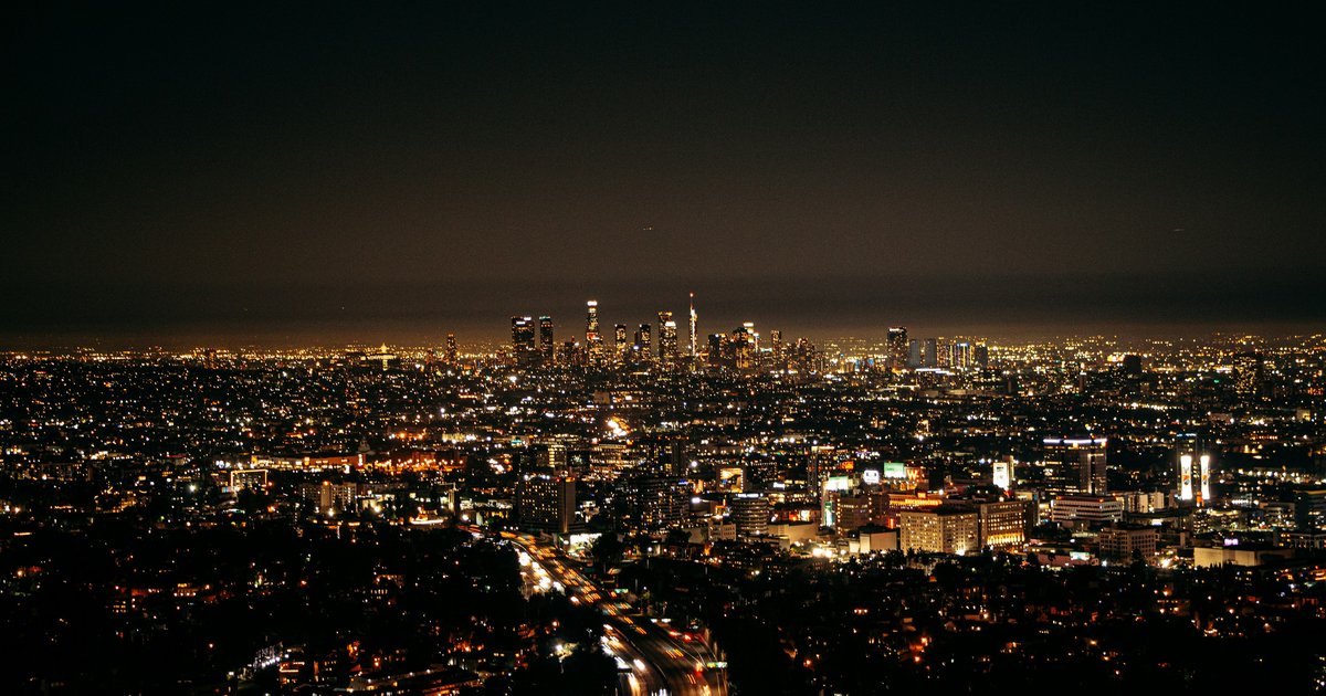 A hillside home in the Hollywood Hills at sunset, seen from Mulholland Drive above the canyon