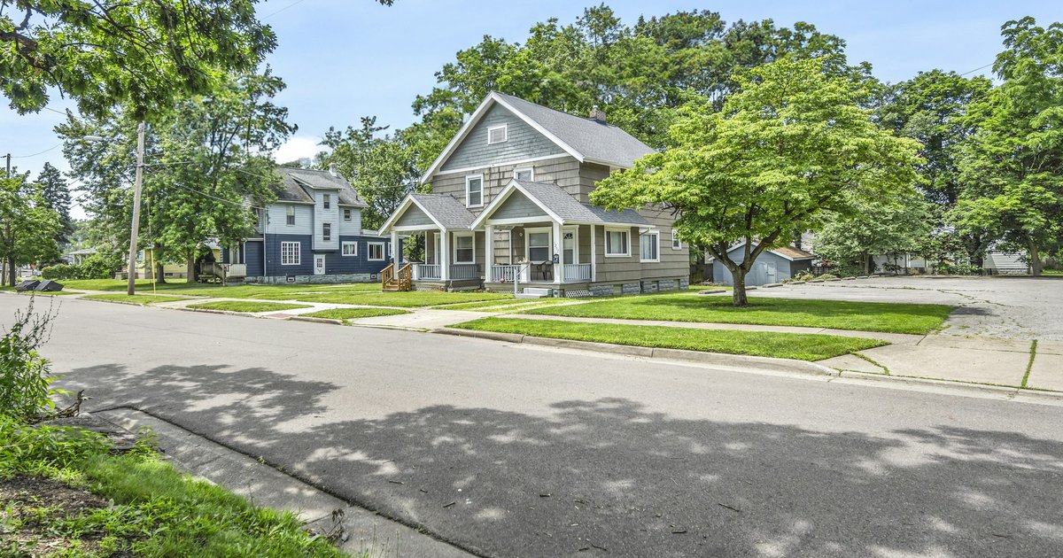 A residential street lined with houses and mature trees, representing the established streets found across Lakewood