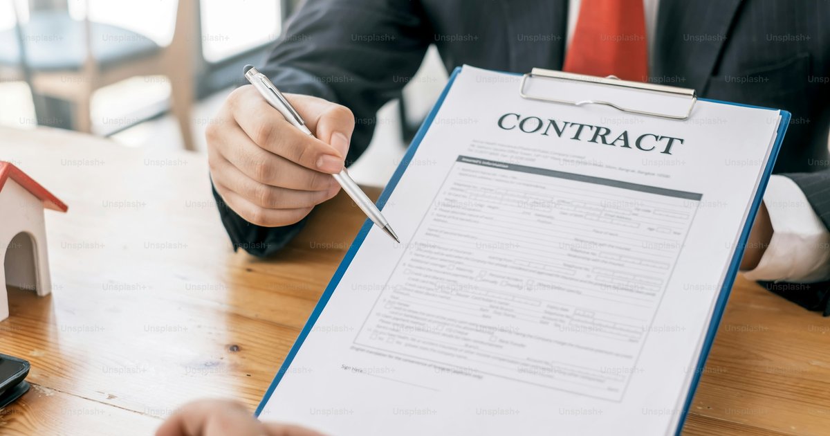 A home finance document, calculator, and pen on a desk, representing the detailed contract review buyers should do before signing any rent-to-own agreement