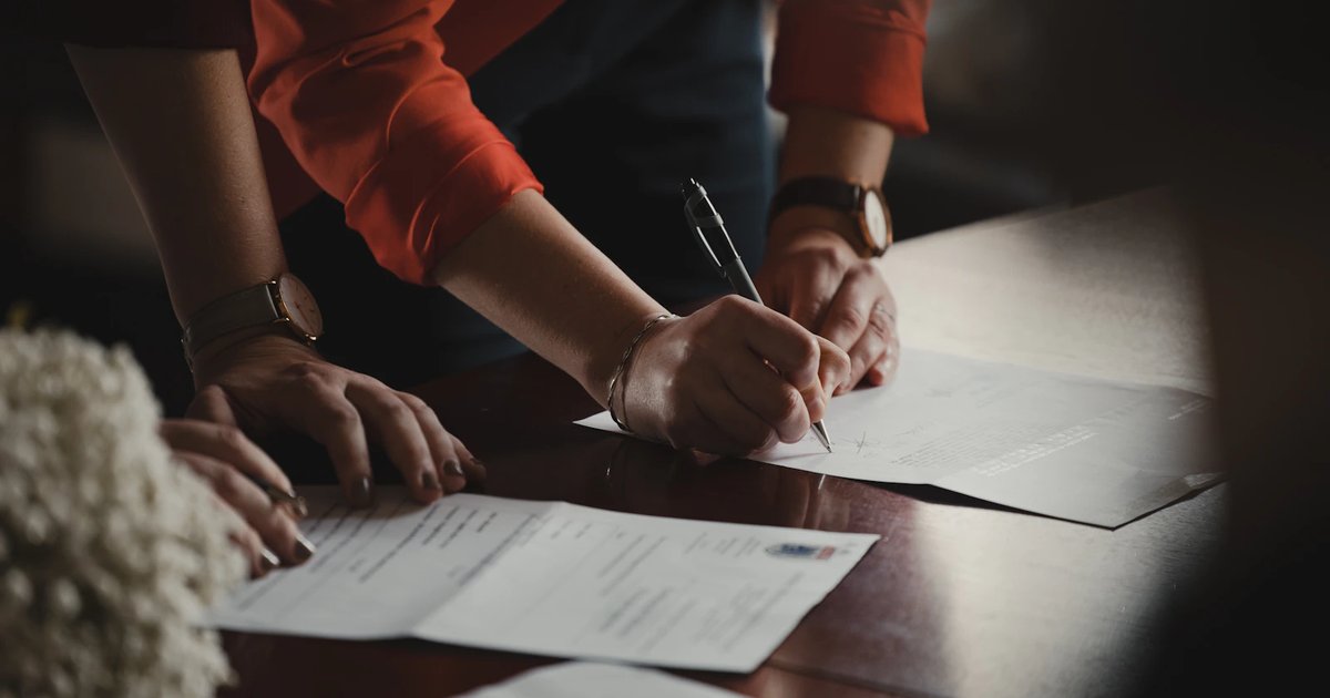 A seller reviewing a real estate contract at a desk, representing the TXR-1101 listing agreement signing process in Texas