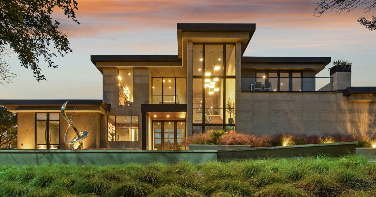 Modern luxury home with large windows at dusk