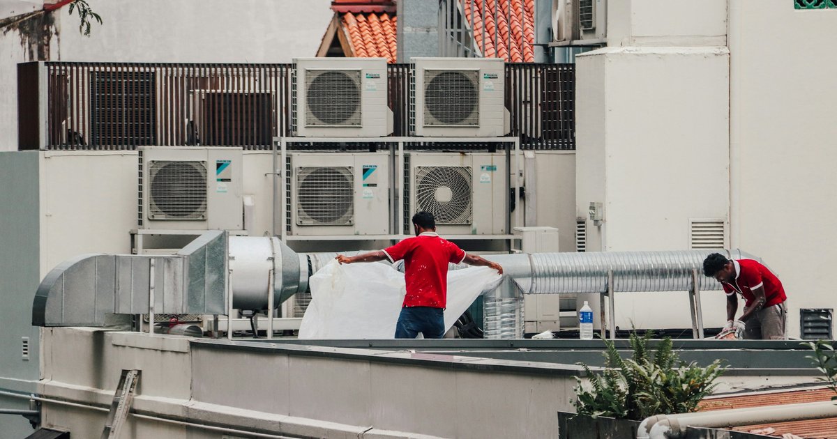An HVAC technician inspecting ductwork and condensate drainage in a Dallas-area home, a common mold risk point in DFW's humid summers