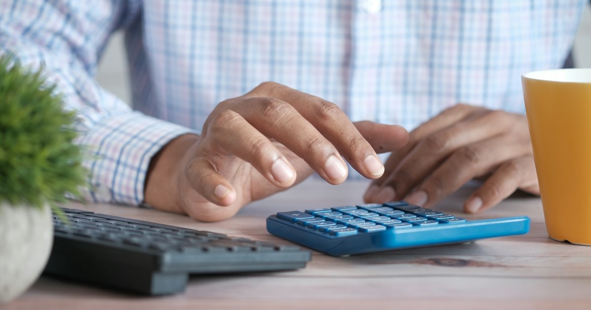 A Dallas homeowner reviewing loan documents and running payment calculations at a home office desk