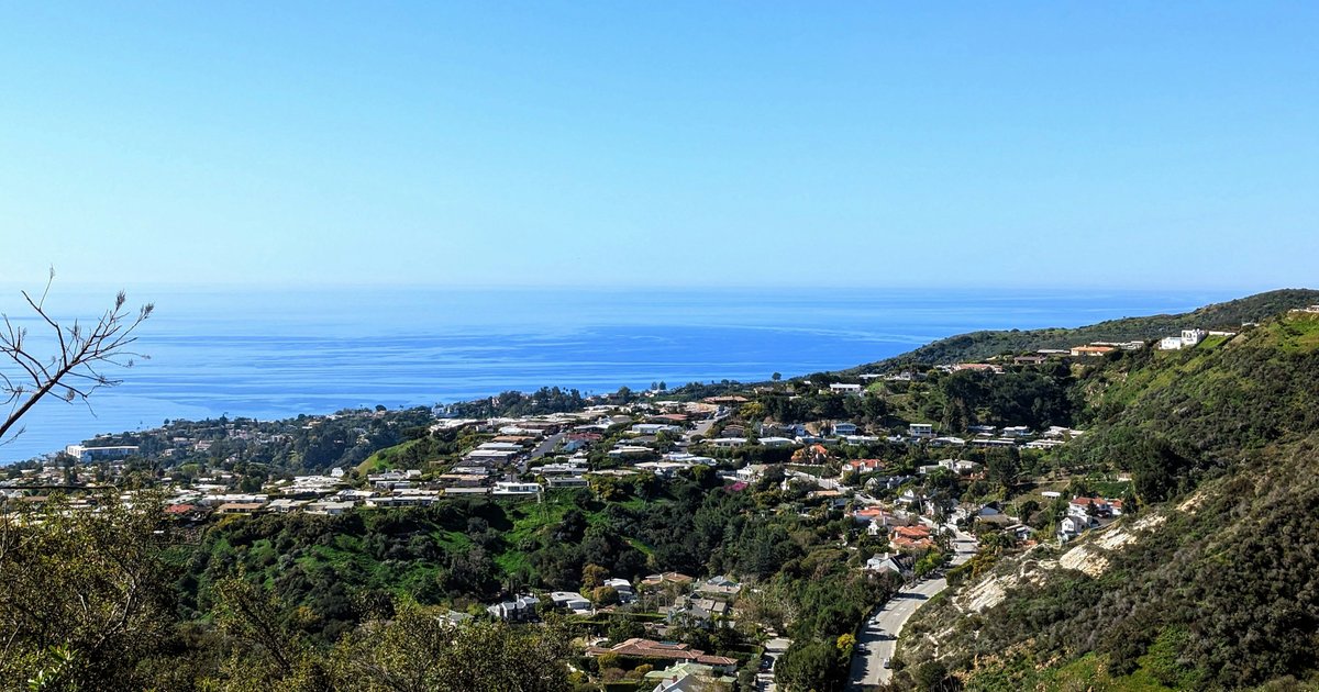 A hillside town overlooking the water, similar to the canyon-and-bluff terrain that defines Pacific Palisades' sub-areas