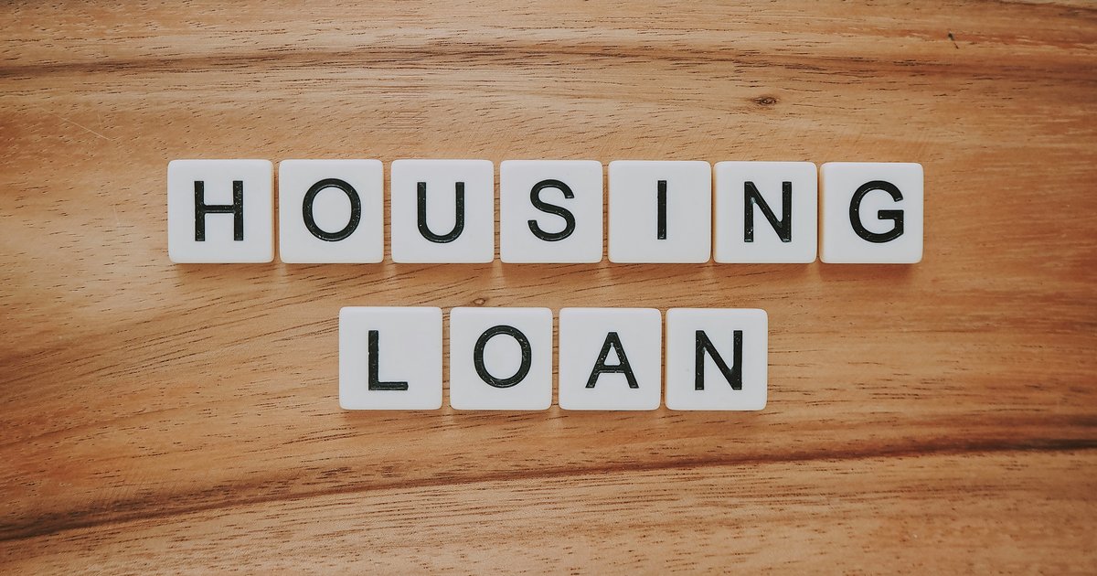 A housing loan display showing blocks spelling out home loan concepts on a wooden surface