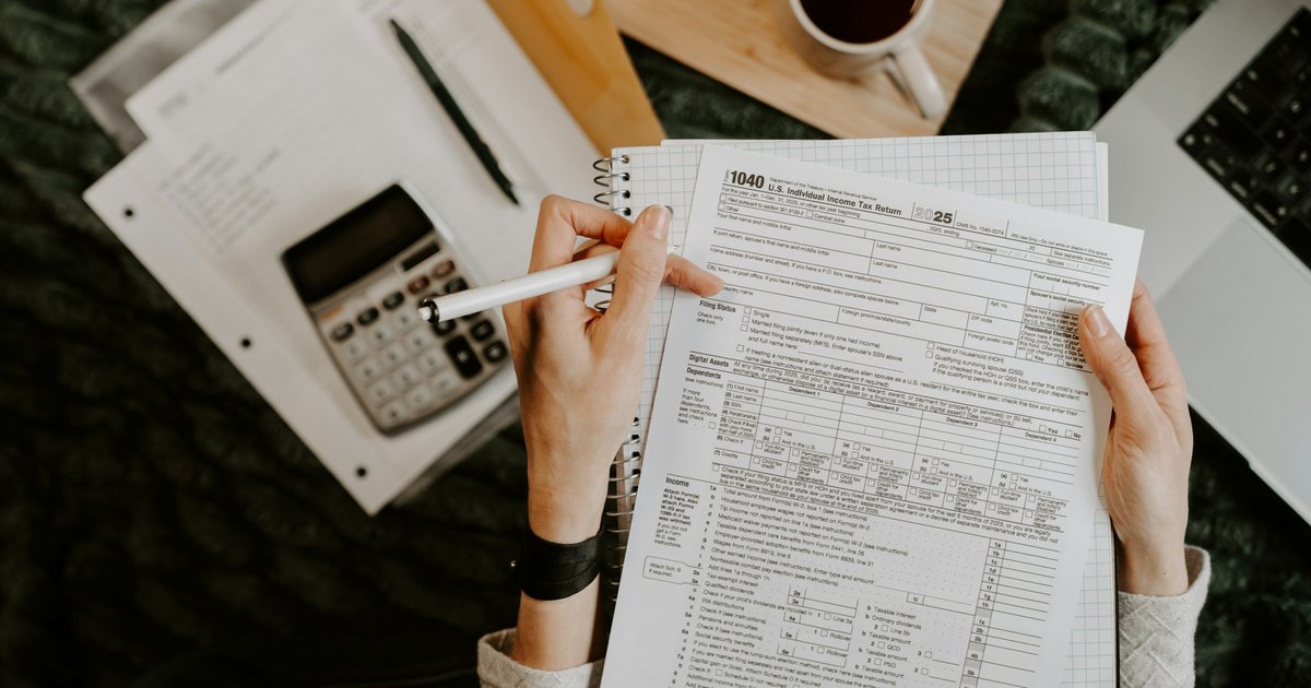 A self-employed buyer in Dallas reviews bank statements and a laptop at a desk, planning for mortgage qualification