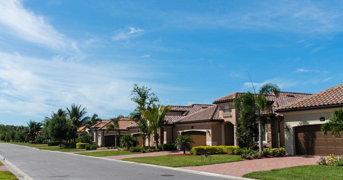 A residential street in a Los Angeles hillside neighborhood with palm trees and Spanish-style homes visible at mid-distance, representing the types of properties often involved in Los Angeles divorce real estate cases