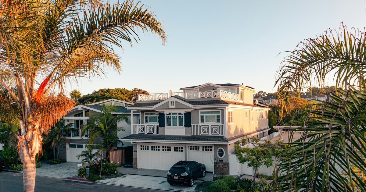 Green trees surrounding a white two-story house in Los Angeles