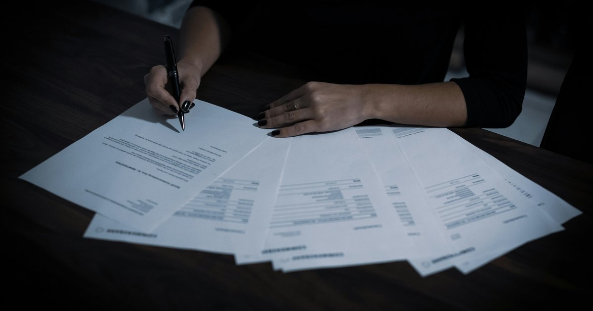 A woman reviewing loan documents at a title company closing table for a Texas home equity loan.