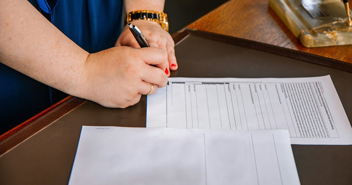 A real estate agent reviewing closing documents with a client at a Dallas title company office