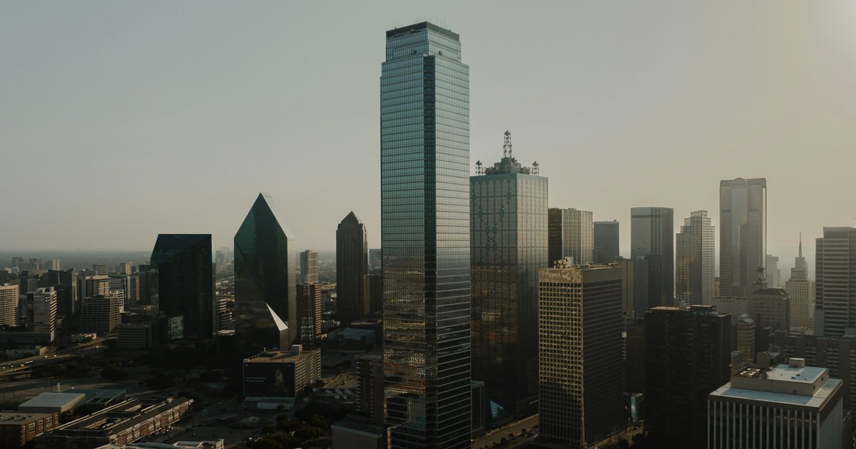 Downtown Dallas high-rise towers at golden hour, seen from the air near Uptown