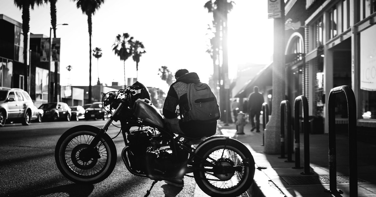 Evening street scene along Abbot Kinney Boulevard in Venice, Los Angeles, with palm trees and storefronts