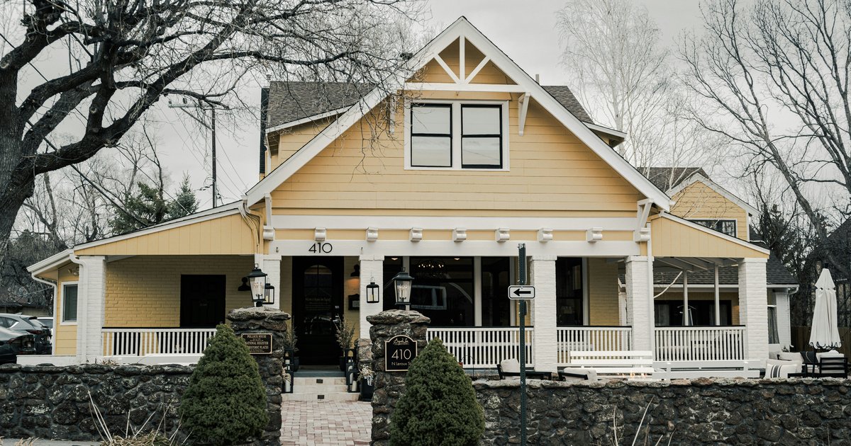 Craftsman style house with a deep covered front porch and tapered white columns, illustrating the bungalow vocabulary found across East Dallas