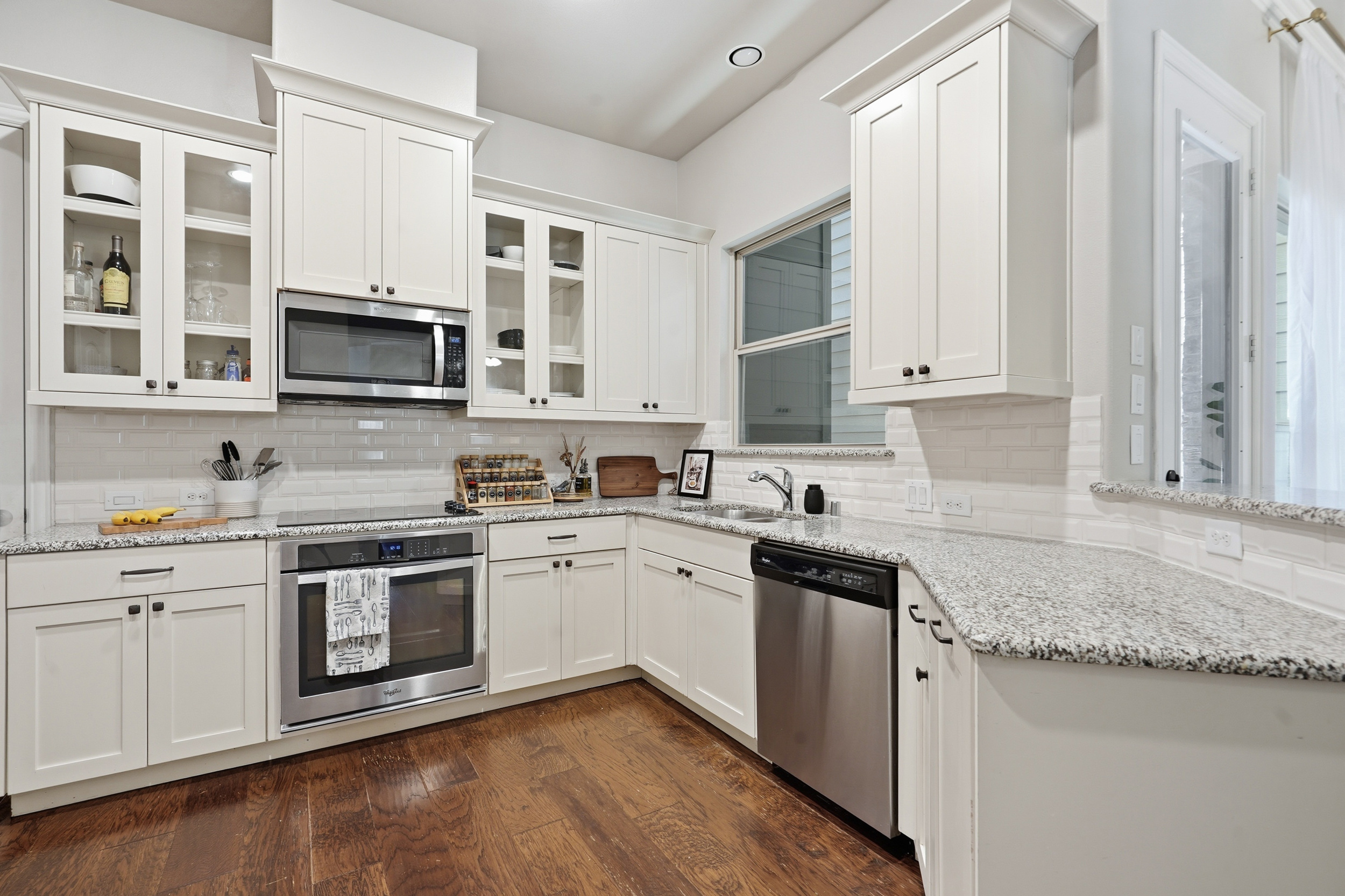 White-cabinet kitchen with granite counters and subway tile backsplash at 853 Rohan Drive, Richardson